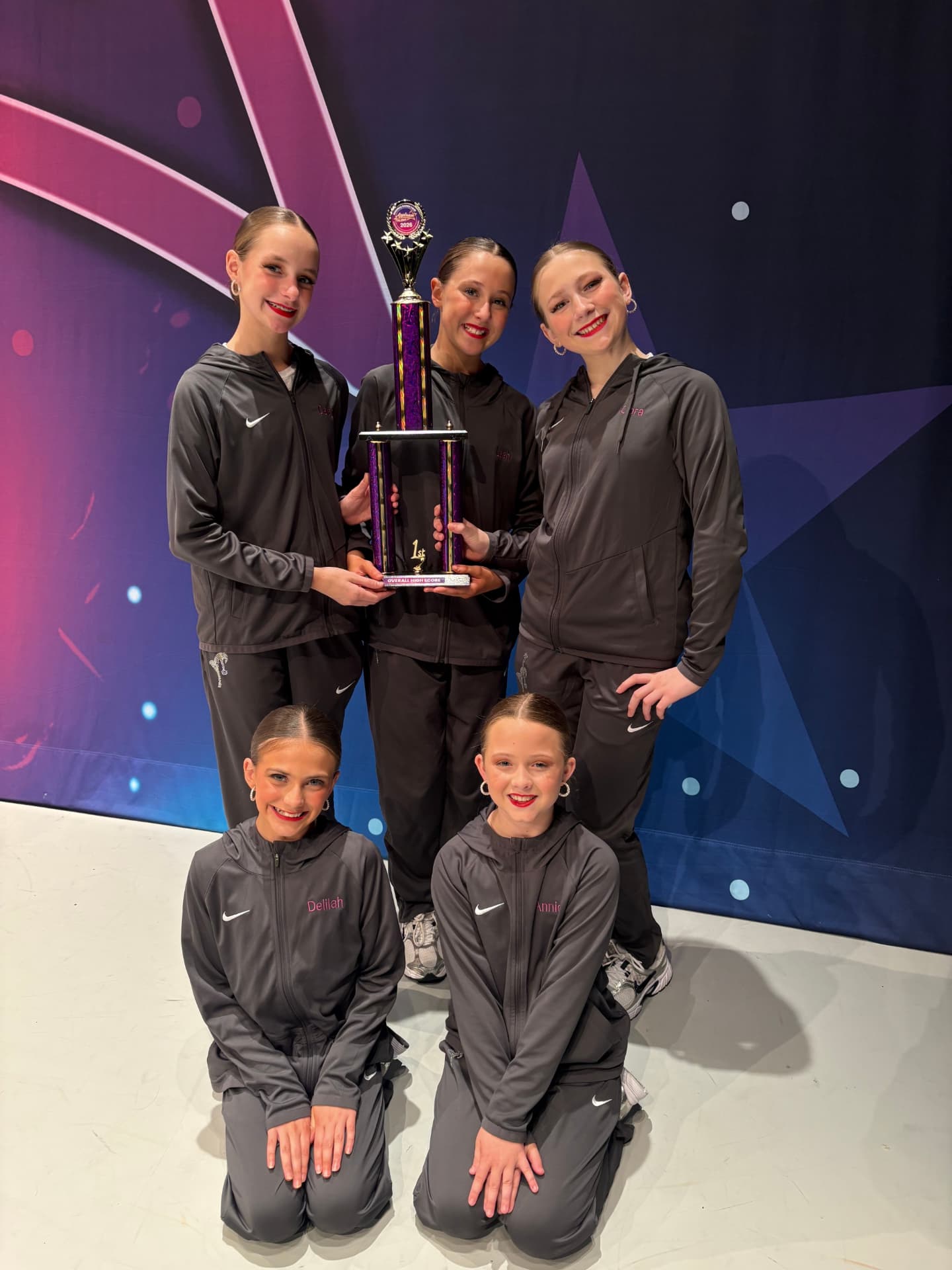 Next Level dancers holding a first place overall high score trophy