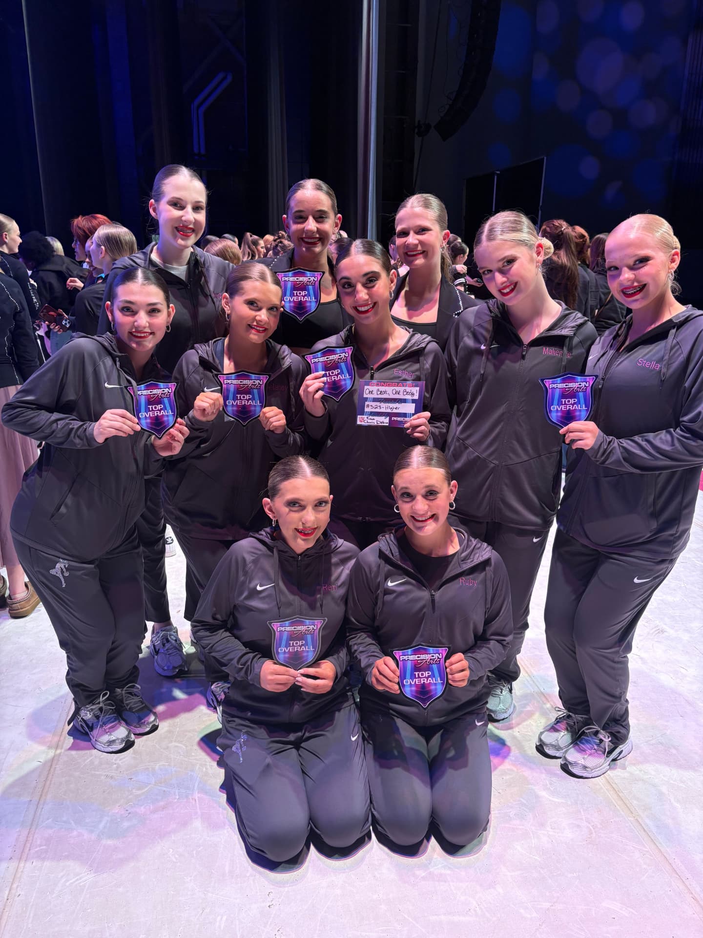 Next Level team holding Precision Arts top overall plaques backstage